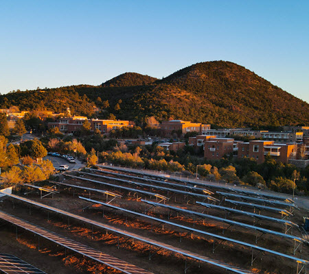 Daytime view of solar car ports at St. John's College with mountains in the background