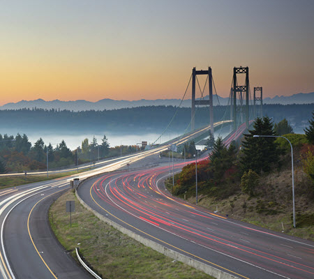 Evening time lapse showing traffic moving across a suspension bridge in Washington state