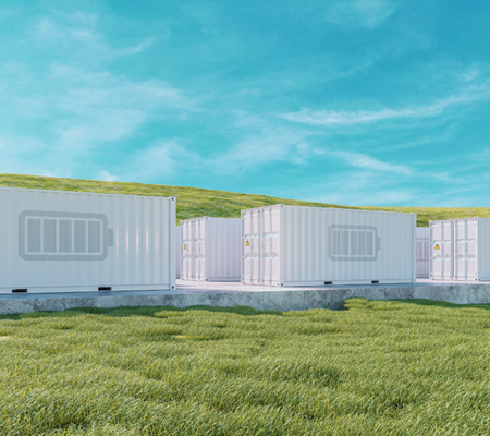 Daytime exterior view of battery energy storage system enclosures in a field under a blue sky