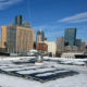 Winter daytime exterior of solar panels on the roof of a building at Northeastern University and a portion of the Boston skyline