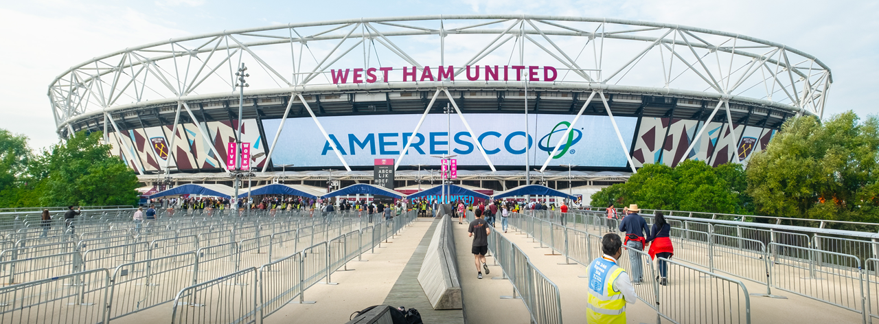 Daytime view of London Stadium displaying an Ameresco banner on the main outer wall